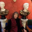 Emily Albu sitting between two ancient busts